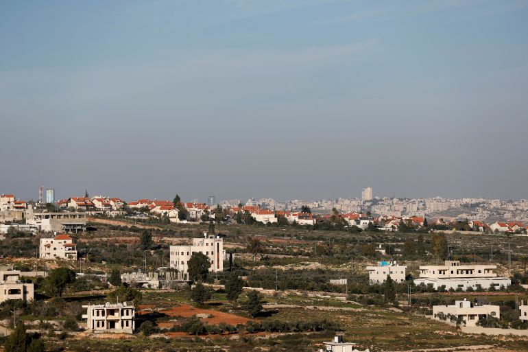 A view shows Palestinian houses as an Israeli settlement is seen in the background near Ramallah in the Israeli-occupied West Bank