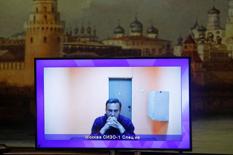 Russian opposition leader Alexei Navalny is seen on a screen via a video link during a court hearing to consider an appeal on his arrest, outside Moscow