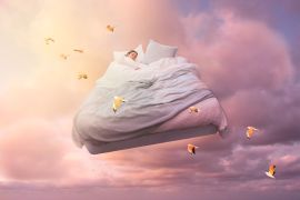 A sleeping girl floats on a bed in the sky and