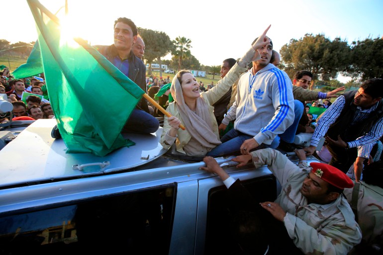 Aisha Gaddafi, daughter of Libya's leader Muammar Gaddafi, greets supporters at Bab Al-Aziziyah in Tripoli