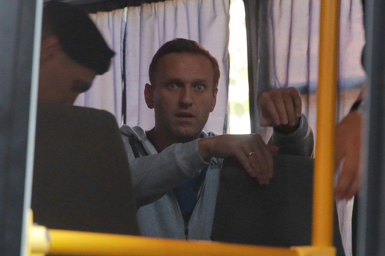 Russian opposition leader Navalny sits in a police bus after a court hearing in Moscow
