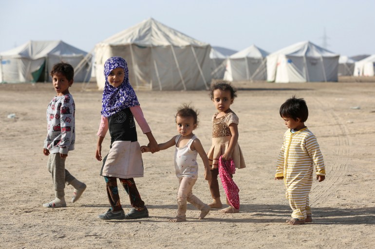Children walk at a camp for people recently displaced by fighting in Yemen's northern province of al-Jawf between government forces and Houthis, in Marib