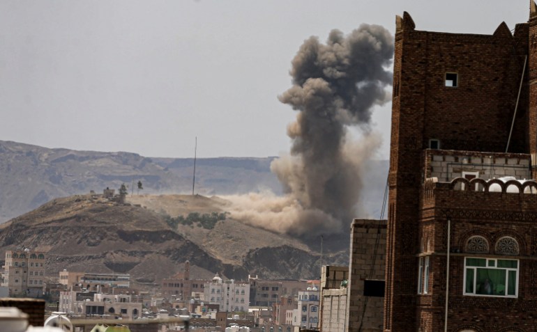 Smoke and dust rise from the site of an air strike on the outskirts of Sanaa