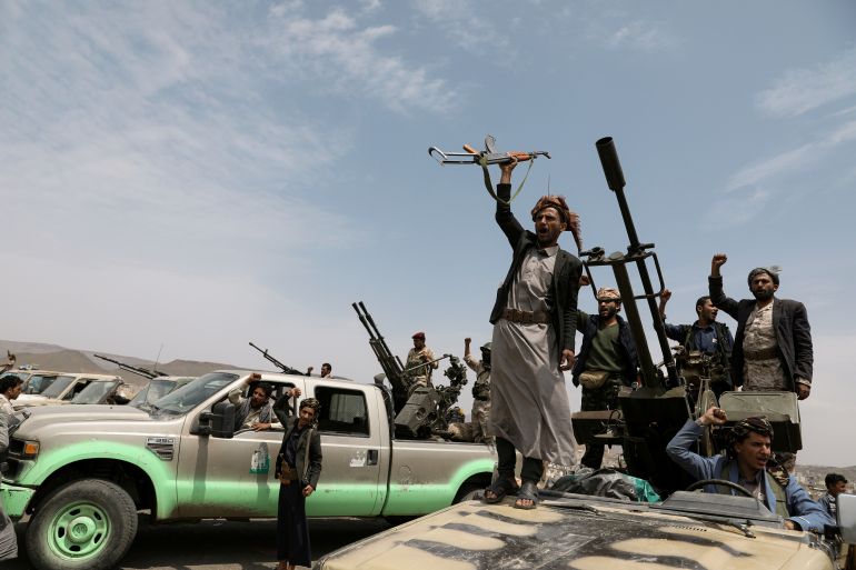 Houthi fighters shout slogans during a gathering of Houthi loyalists on the outskirts of Sanaa