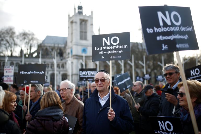 Protesters hold placards and flags during a demonstration, organised by the British Board of Jewish Deputies for those who oppose anti-Semitism, in Parliament Square in London