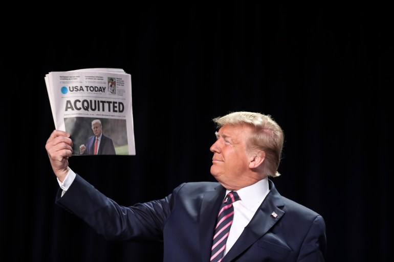 ترامب يحمل صحيفة يو اس توداي التي عنونت ببراءته نوفمبر الماضي
