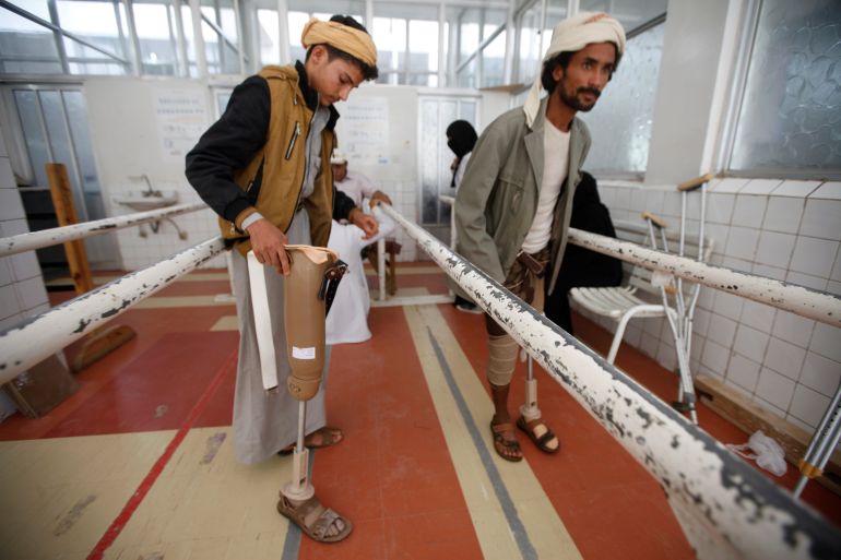 Men with amputated legs test artificial legs at a prosthetic limbs centre in Sanaa, Yemen