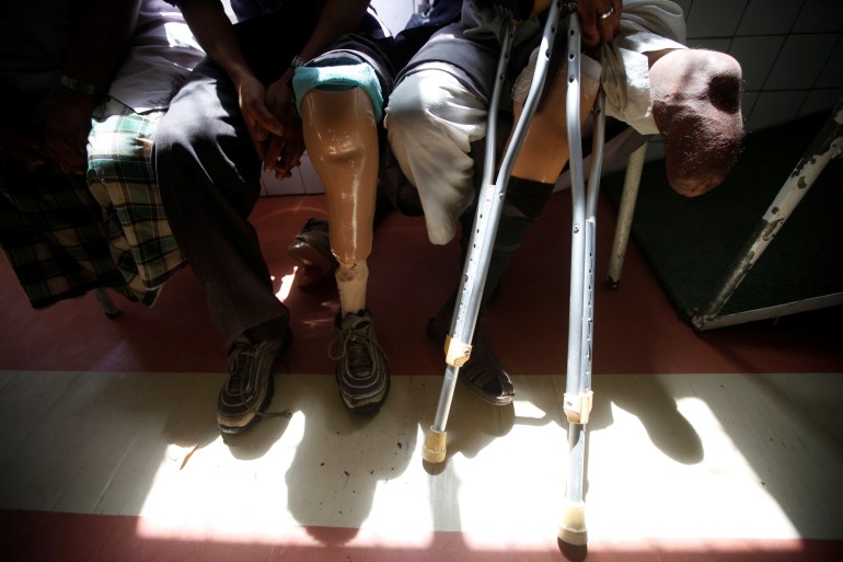 Men with amputated legs sit at a prosthetic limbs centre in Sanaa, Yemen