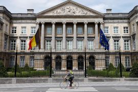 A cyclist rides past the Belgian Parliament prior to a vote on an embargo on weapon sales to Saudi Arabia, in Brussels