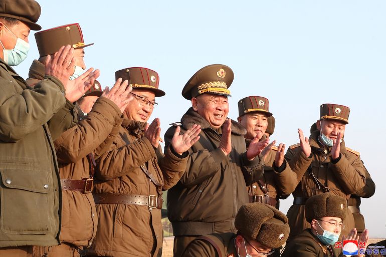 Ri Pyong Chol, the senior leader who is overseeing the test, and other military officials applaud after the launch of a newly developed new-type tactical guided projectile