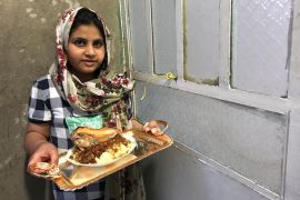 طفلة عراقية وهي تحمل طبق رمضاني حيث يتبادل الجيران والاهل الاطباق في شهر رمضان كتقليد متوارث عبر الاجيال