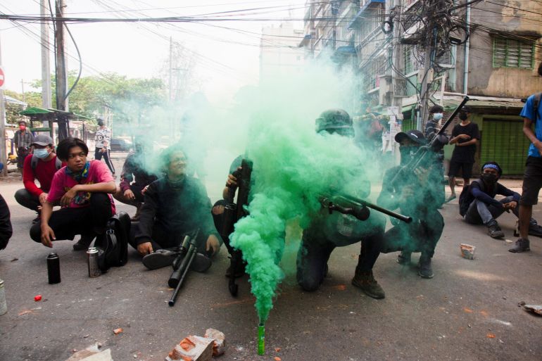 Protesters hold homemade pipe air guns during a protest against the military coup in Yangon