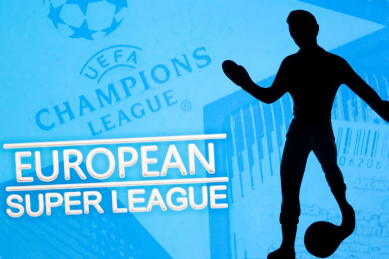 A metal figure of a football player with a ball is seen in front of the words "European Super League" and the UEFA Champions League logo in this illustration A metal figure of a football player with a ball is seen in front of the words "European Super League" and the UEFA Champions League logo in this illustration taken April 20, 2021. REUTERS/Dado Ruvic/Illustration