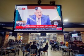 A screen displaying a live broadcast of the Palestinian President Mahmoud Abbas's speech during a meeting discuss upcoming elections, is seen in a coffee shop in Ramallah