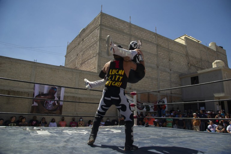 Mexican wrestlers take part in the clandestine backyard show Hall of Fame, mounted by extreme wrestling organizer Zona 23, which pays tribute to wrestler Israel Montiel Leon, "Ovett", who died of COVID-19 in February this year at the age of 44, and two other fighters, in Cuautitlan Izcalli, Mexico State, Mexico, on April 4, 2021. - Almost 200 Mexican extreme wrestlers have died from COVID-19, their worst contender. (Photo by Claudio CRUZ / AFP) (Photo by CLAUDIO CRUZ/AFP via Getty Images)
