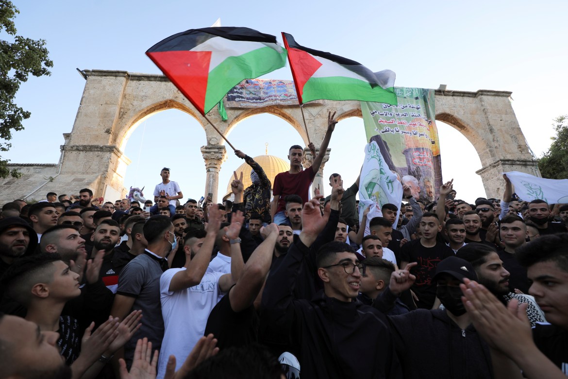 فلسطينيون يرفعون علم بلادهم بساحات الأقصى عقب صلاة عيد الفطر في رسالة إلى سلطات الاحتلال الإسرائيلي تؤكد تمسكهم بالقدس والأقصى (رويترز)