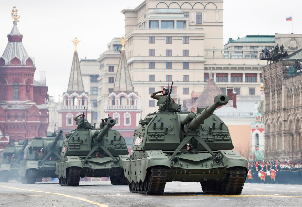 Russian service personnel salute as they pass by self-propelled howitzers during the military parade on Victory Day (Reuters)