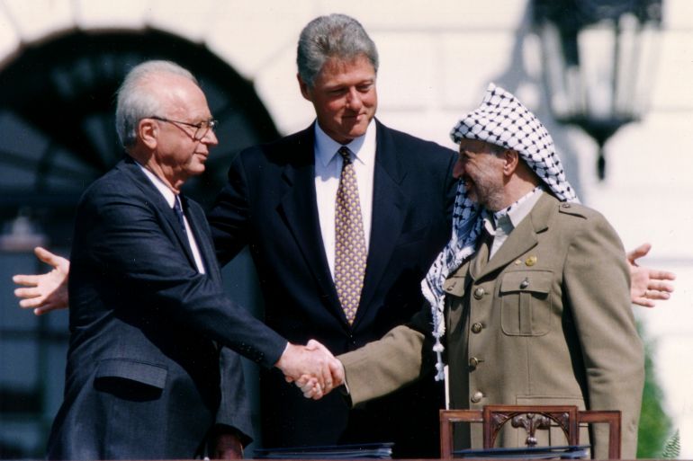 PLO Chairman Arafat shakes hands with Israeli PM Rabin after the signing of the Israeli-PLO peace accord, in Washington