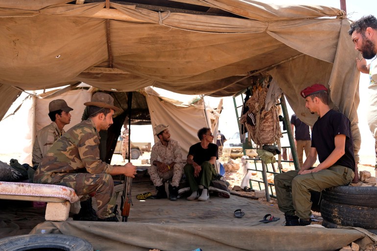 Members of the Libyan National Army (LNA) commanded by Khalifa Haftar sit inside a tent at one of their sites in west of Sirte