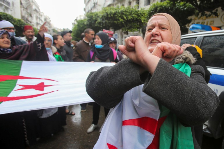 Woman gestures during a protest demanding political change, in Algiers