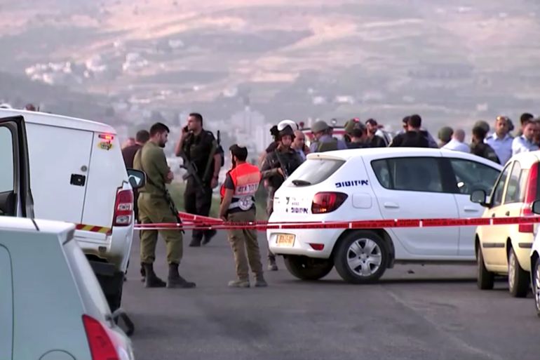 Members of Israeli forces gather at the scene of a shooting incident in the Israeli-occupied West Bank