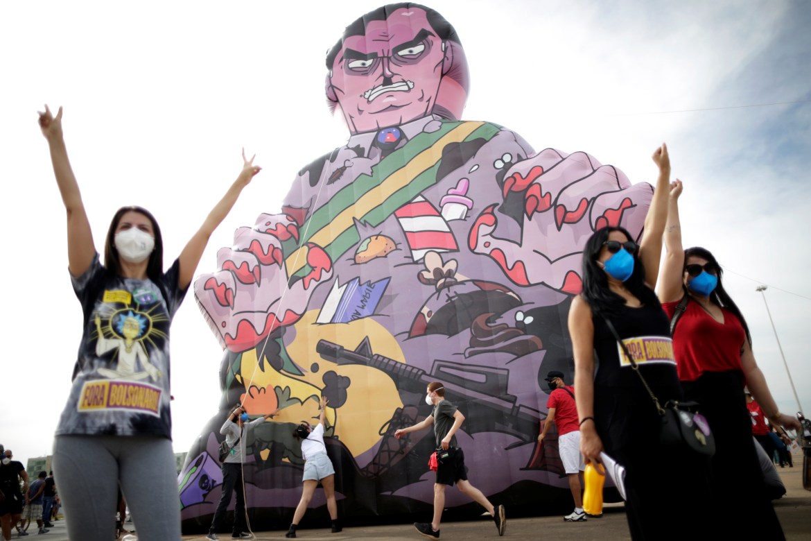Demonstrators set up an inflatable doll known as "Bexolico", which means bribery in Portuguese, and photographed President Bolsonaro during a protest against him in the capital, Brasilia (Reuters)