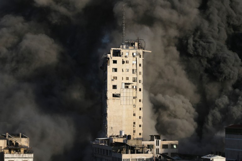 Smoke engulfs a tower building as it is destroyed by Israeli air strikes amid a flare-up of Israeli-Palestinian violence, in Gaza City May 12, 2021. REUTERS/Ibraheem Abu Mustafa