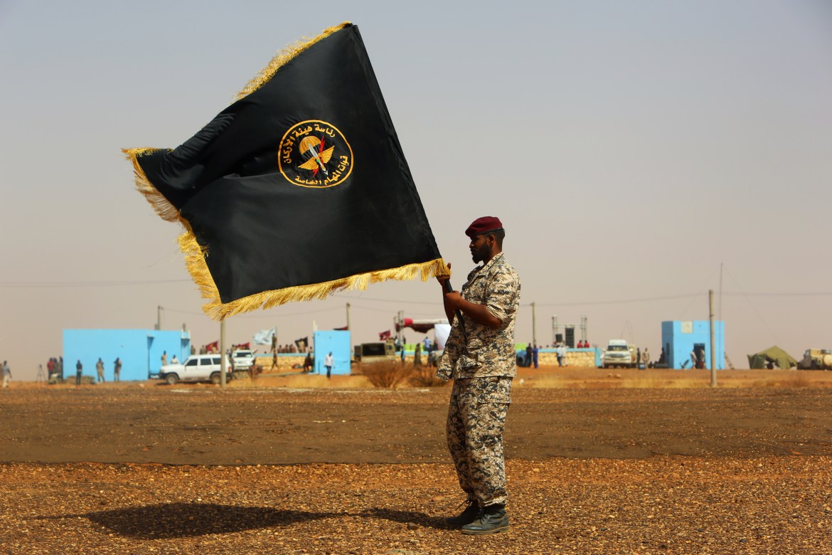 A member of the Sudanese army carries the flag of the Sudanese forces during the joint military exercise in the North Omdurman (European) region