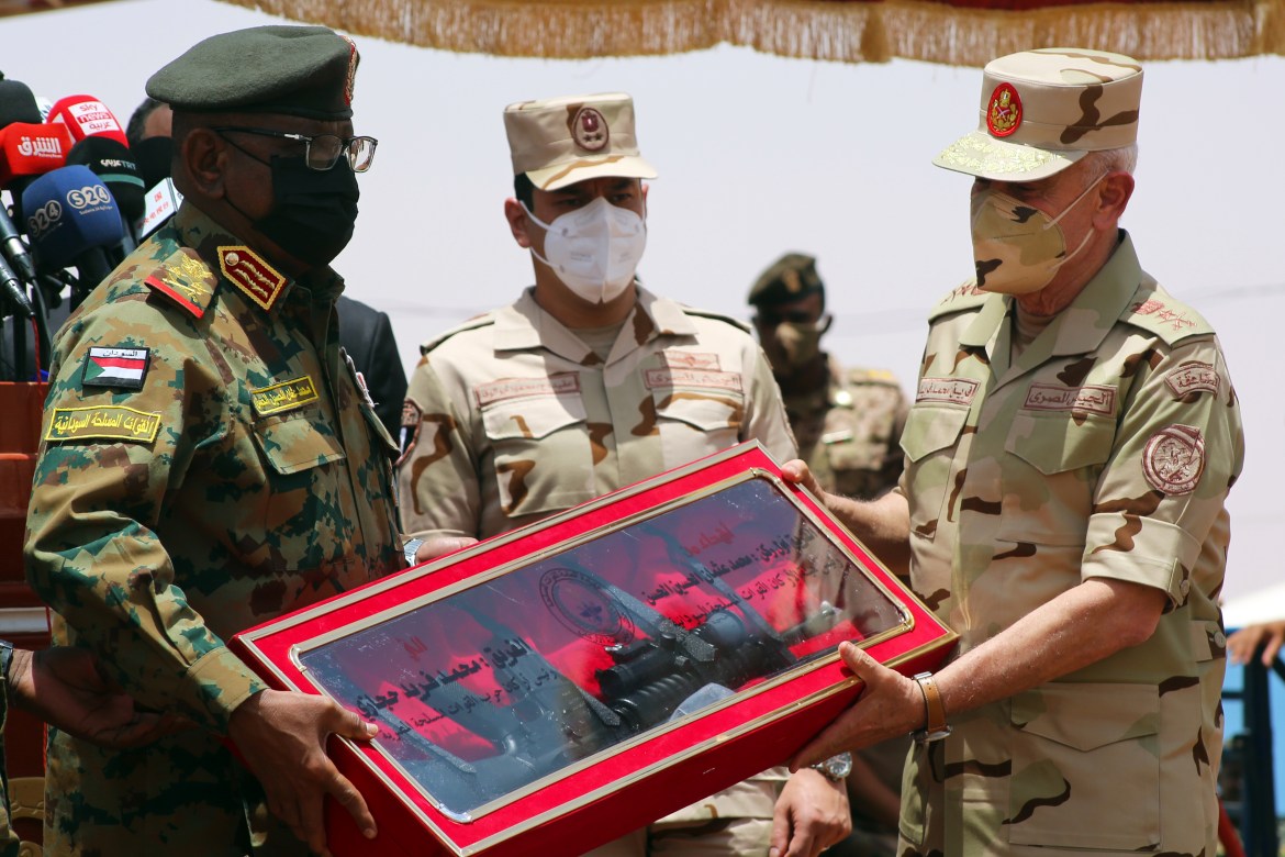 Sudanese Chief of Staff Muhammad al-Hassan (left) presents his Egyptian counterpart Muhammad Farid a weapon made in Sudan at the conclusion of the (European) exercises