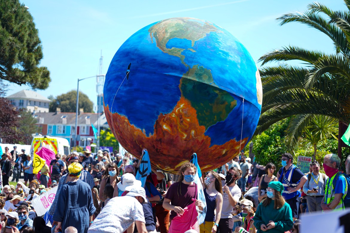 Demonstrators carry a giant globe-shaped balloon during a rally in downtown Falmouth (Getty)