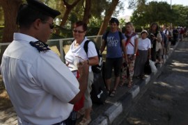 An Egyptian policeman check passports of tourists at the Taba crossing between Egypt and Israel