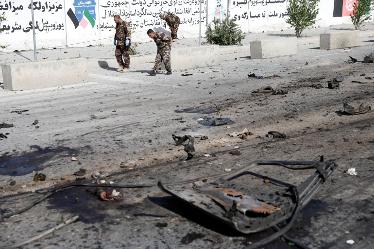 Afghan security forces inspect the site of a blast in Kabul