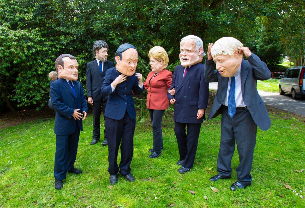 Protesters wearing masks representing the faces of the leaders of the Group of Seven countries participating in the summit, and they are - from right to left - British Prime Minister Boris Johnson, US President Joe Biden, German Chancellor Angela Merkel, Japanese Prime Minister Yoshihide Suga, his Italian counterpart Mario Draghi, and the French President Emmanuel Macron (European)