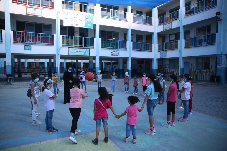 الجزيرة/غزة/ حلقة من الأطفال يلعبون في ساحة المدرسة.