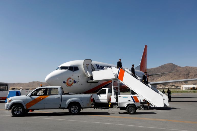 Crew members of a private airline depart from a plane at the Kabul International Airport in Kabul