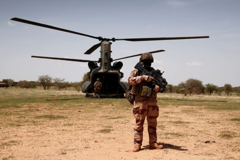 A French soldier of the the "Belleface" Desert Tactical Group (GTD) secures a Boeing CH-47 Chinook military helicopter of the British army during the Operation Barkhane in Ndaki