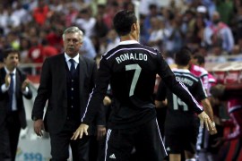 Real Madrid's Ronaldo celebrates his third goal against Sevilla while coach Ancelotti watches him during their Spanish first division soccer match in Seville