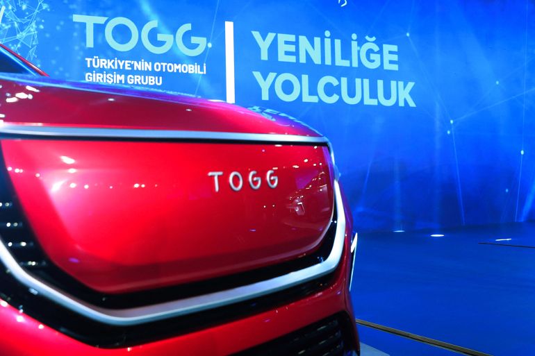 A handout photograph taken and released by the Turkish President press service on December 27, 2019 shows Turkish President Recep Tayyip Erdogan delivering a speech next to the firsts Turkish made electric cars by the TOGG company, during the launching ceremony in the Gebze district of Kocaeli. - Production facilities were announced to be completed in 2021 and the first car to be produced in 2022. Turkey has mobilised 750 million Turkish liras (over 126 million US dollar) to fund innovation and regional development, according to the country's industry and technology minister. (Photo by MURAT CETINMUHURDAR / TURKISH PRESIDENTIAL PRESS SERVICE / AFP) / RESTRICTED TO EDITORIAL USE - MANDATORY CREDIT "AFP/TURKISH PRESIDENTIAL PRESS SERVICE/MURAT CETINMUHURDAR" - NO MARKETING - NO ADVERTISING CAMPAIGNS - DISTRIBUTED AS A SERVICE TO CLIENTS
