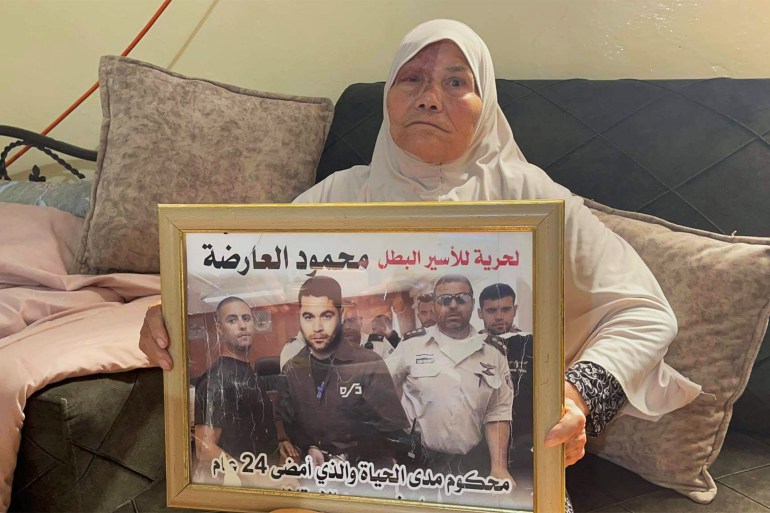 فتحية العارضة والدة الاسير محمود تحمل صورته - الضفة الغربية - جنين- عرابة- الصورة خاصة بالجزيرة نت