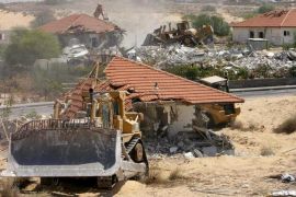 جرافات ومعدات حفر إسرائيلية تهدم منازل في مستوطنة نيفي ديكاليم اليهودية السابقة في قطاع غزة في 31 أغسطس/آب 2005 (رويترز-أرشيف)