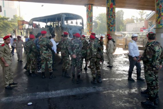حافلة نقل الجنود تفحمت من شدة الانفجار تحت جسر وسط دمشق (رويترز)