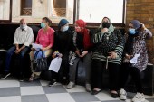 مصريون في أحد المستشفيات ينتظرون دورهم لتلقي لقاح فيروس كورونا (رويترز)