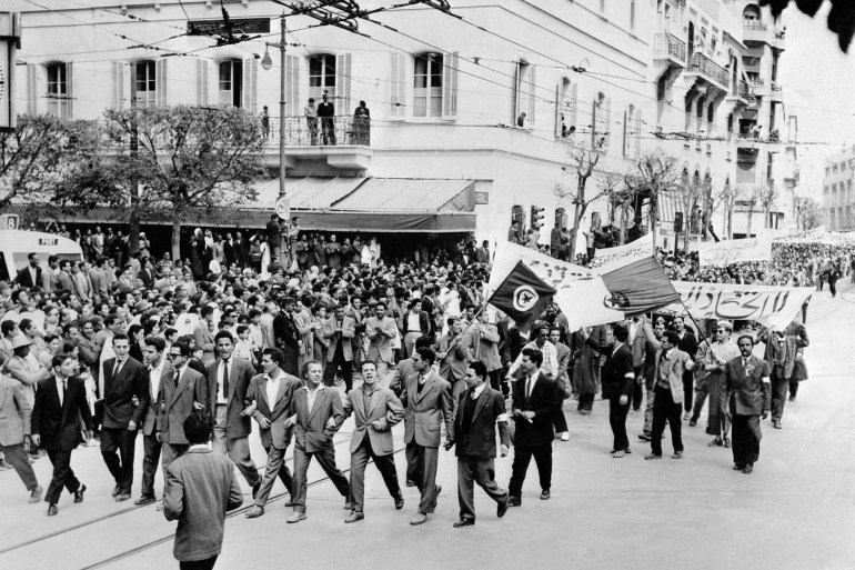 Demonstrators supporting the independence of Algeria parade through the streets of Tunis on May 1, 1956 by displaying flags and banners of the FLN (Front of National Liberation). (Photo by - / INTERCONTINENTALE / AFP) (Photo credit should read -/AFP via Getty Images)