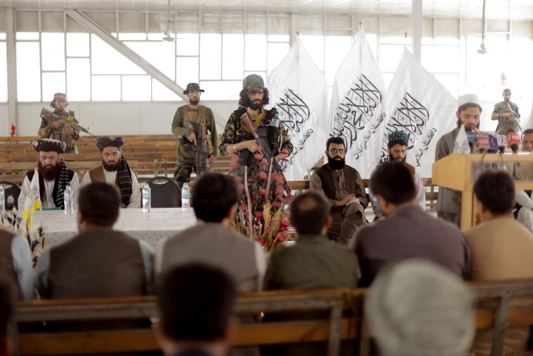 Afghanistan Taliban officials pray befiore the start of a news conference where they announced they will start issuing passports