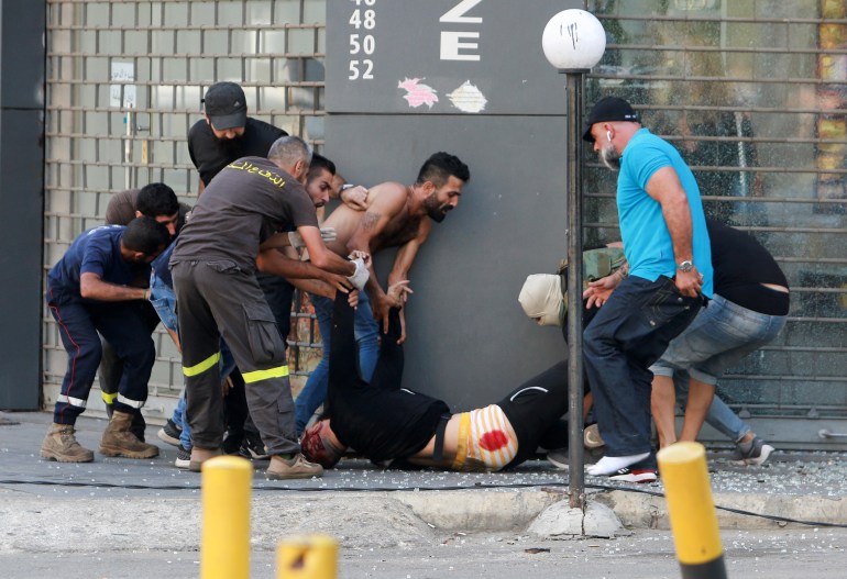 People evacuate a casualty after gunfire erupted in Beirut