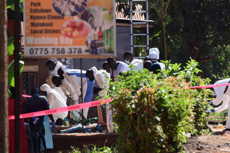 Ugandan explosives experts inspect the debris at the scene of an explosion in Komamboga, on the northern outskirts of Kampala