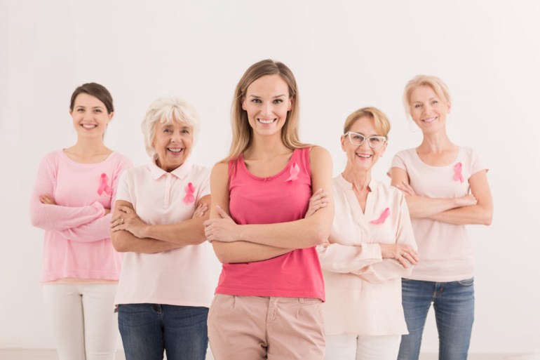 Group of smiling confident women wearing pink