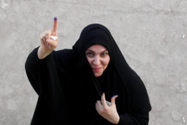 A woman shows her ink-stained finger after casting her vote at a polling station during the parliamentary election, in Najaf, in Iraq, October 10, 2021. REUTERS/Alaa Al-Marjani