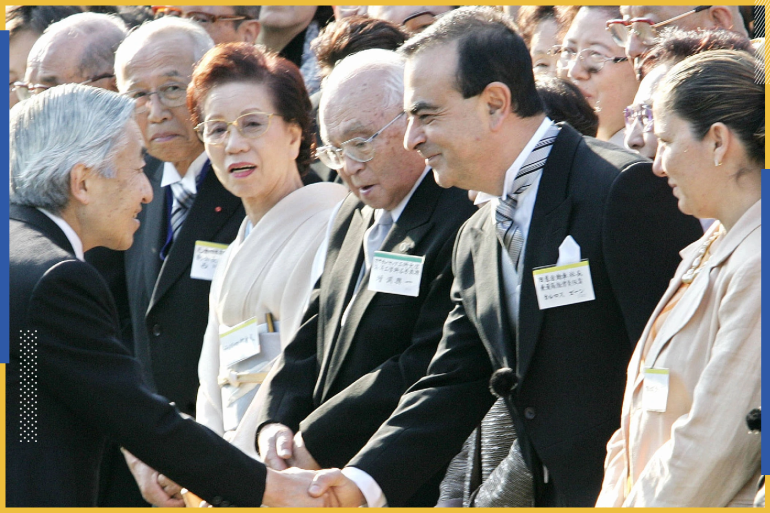 كارلوس غصن يصافح إمبراطور اليابان الذي منحه ميدالية الشريط الأزرق كأول مدير أعمال أجنبي ينال هذا التكريم (رويترز)