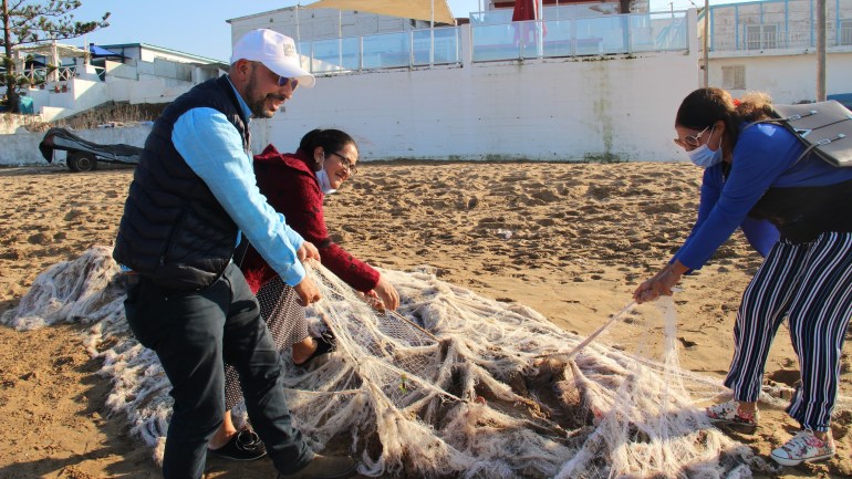 الصورة 2: سناء القويطي/ الصخيرات/ فريق جمعية صفر قمامة يجمع شباك الصيد من الشاطئ المصدر: الجزيرة